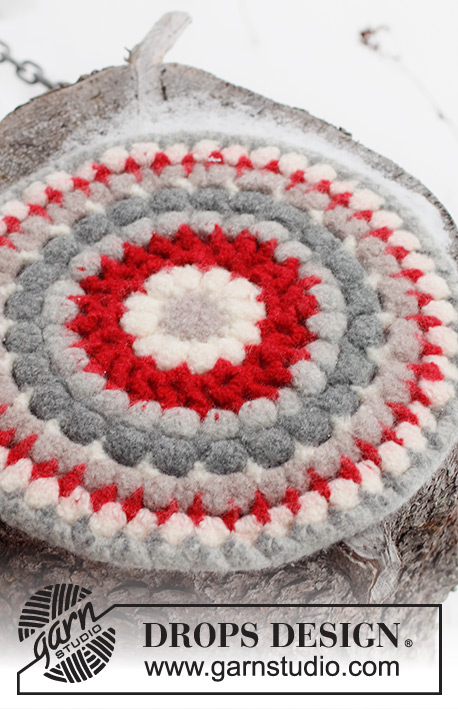 Merry Seat / DROPS Extra 0-1571 - Crocheted and felted sitting mat in DROPS Snow. The piece is worked in the round from the middle outwards. Theme: Christmas.