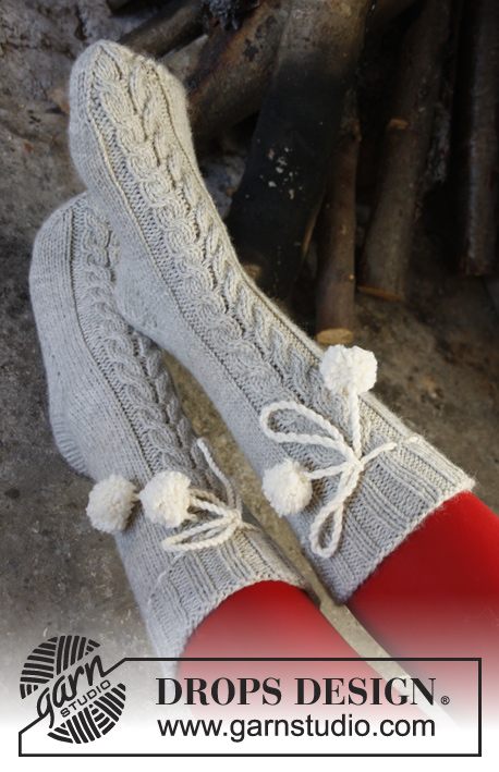 Fireside Snuggle / DROPS Extra 0-992 - DROPS Weihnachten: Gestrickte DROPS Socken mit Zöpfen in „Nepal“.