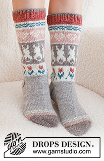 Dancing Bunny Socks / DROPS 229-34 - Strikkede sokker i DROPS Karisma. Arbejdet strikkes oppefra og ned, i glatstrik med flerfarvet mønster med hjerte, hare / påskehare og blomst. Størrelse 35 - 46. Tema: Påske.