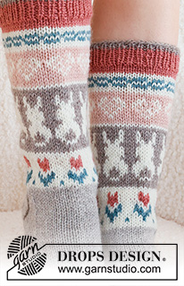 Dancing Bunny Socks / DROPS 229-34 - Gestrickte Socken in DROPS Karisma. Die Arbeit wird von oben nach unten glatt rechts mit mehrfarbigem Muster mit Herz, Hase / Osterhase und Blumen gestrickt. Größe 35 - 46. Thema: Ostern.