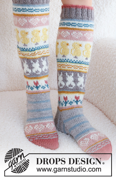 Easter Dance Socks / DROPS 229-35 - Knitted socks in DROPS Karisma. The piece is worked top down in stockinette stitch, with multi-colored pattern and heart, Easter chick, Easter bunny and flower. Sizes 35 – 43 = US 4 1/2 - 12 1/2.. Theme: Easter.