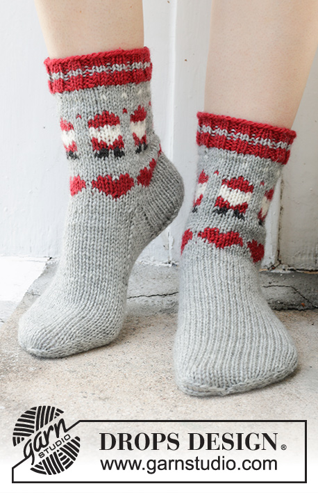 Santa Time Socks / DROPS 234-65 - Gebreide sokken in DROPS Karisma. Het werk wordt van boven naar beneden gebreid met gekleurde kerstman en hartpatroon. Maten 35 – 43. Thema: Kerst.