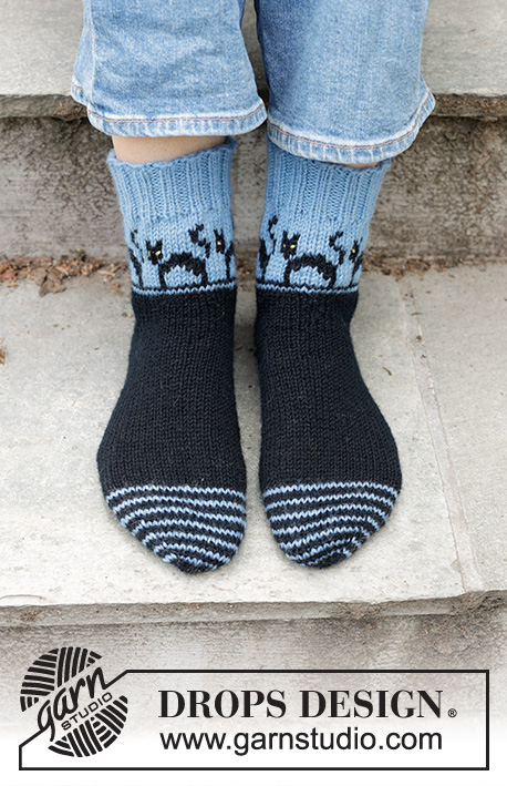 Spooky Evening Socks / DROPS 244-45 - Stickade strumpor i DROPS Karisma. Arbetet stickas från tån och upp med flerfärgat mönster med katter och kilhäl. Storlek 35-43. Tema: Halloween.