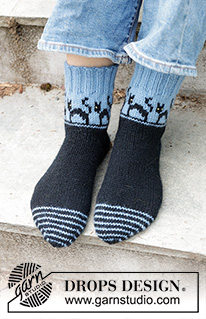 Spooky Evening Socks / DROPS 244-45 - Gebreide sokken in DROPS Karisma. Het werk wordt gebreid vanaf de teen in de hoogte, met een veelkleurig patroon met katten en wighak. Maten 35-43. Thema: Halloween.
