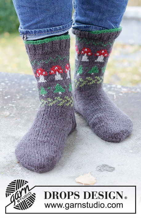 Mushroom Season Socks / DROPS 246-43 - Calze da uomo a metà lunghezza lavorate ai ferri in DROPS Karisma. Lavorate dall’alto in basso con motivo multicolore con funghi e alberi di Natale. Taglie: 35 – 46. Tema: Natale.