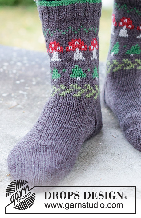 Mushroom Season Socks / DROPS 246-43 - Gebreide halflange sokken voor heren in DROPS Karisma. Het werk wordt van boven naar beneden gebreid, met veelkleurige paddenstoelen en kerstbompatroon. Maten 35 – 46. Thema: Kerst.