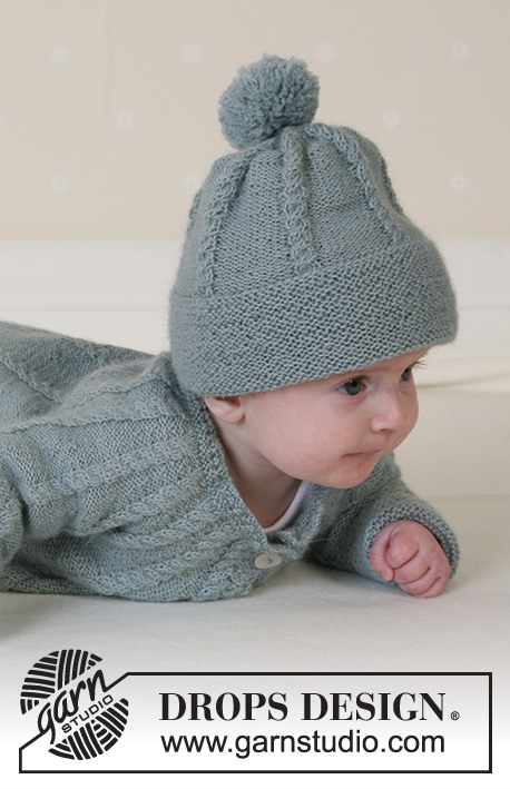 Lille Trille / DROPS Baby 14-2 - Gilet tricoté avec empiècement arrondi et torsades, bonnet avec pompon, moufles et chaussettes en DROPS Alpaca pour bébé et enfant. Du 1 au 3 ans.