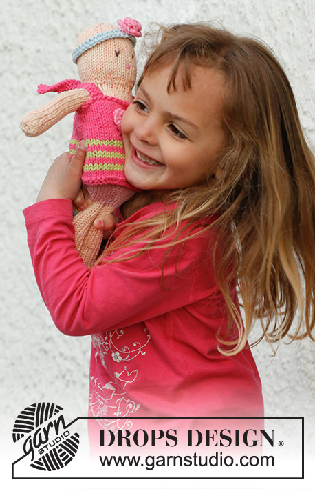 Mimi / DROPS Children 23-25 - Boneca menina em tricô com vestido e fita de cabelo em DROPS Paris.