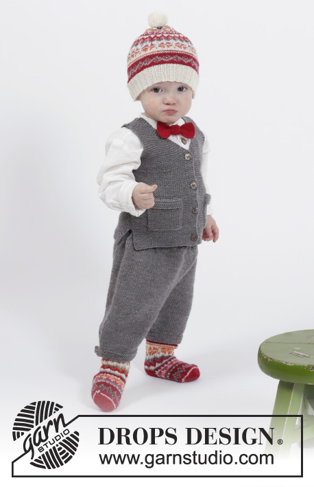 Goofy Gavin / DROPS Children 26-15 - Komplekt: DROPS BabyMerino lõngast ripskoes kootud taskutega ja V-kaelusega vest ning lühikesed püksid, DROPS Fabel lõngast kirjatud mustriga beebi / laste müts ja sokid, ning kikilips suurustele 1 kuune kuni 6 aastane.
