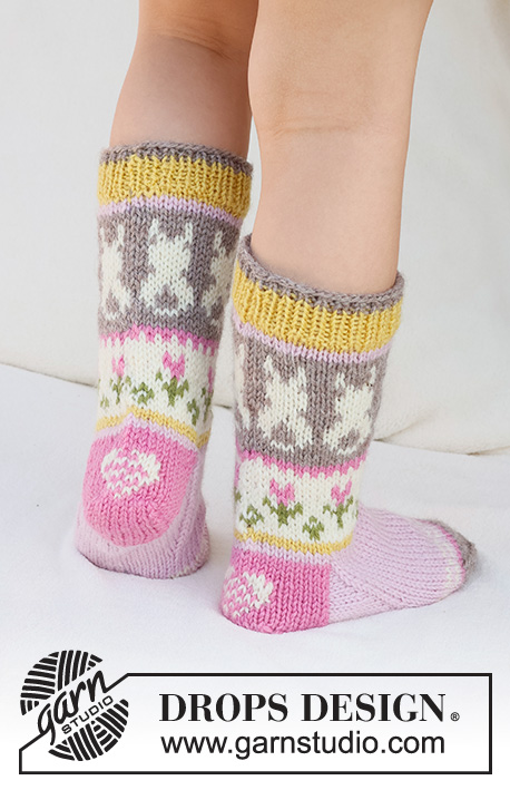 Dancing Bunny Socks / DROPS Children 41-35 - Knitted socks for children in DROPS Karisma. The piece is worked top down in stocking stitch, with multi-coloured pattern and heart, Easter chick, Easter bunny and flower. Sizes 24 - 43. Theme: Easter.