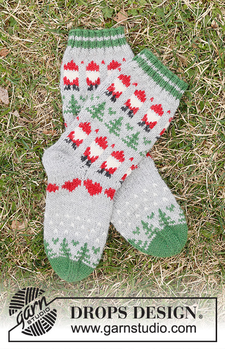 Christmas Time Socks / DROPS Children 44-20 - Calcetines de punto para niños en DROPS Karisma. La pieza está tejida de arriba hacia abajo con patrón de jacquard multicolor de Papá Noel, árbol de Navidad y corazón. Números 24 – 43. Tema: Navidad.