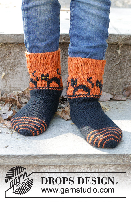Spooky Sunset Socks / DROPS Children 47-29 - Lapsen neulotut sukat DROPS Karisma-langasta. Työ neulotaan kärjestä ylöspäin. Työssä on kirjoneuletta, kissakuvioita ja kiilakantapää. Koot 35-43. Teema: Halloween.